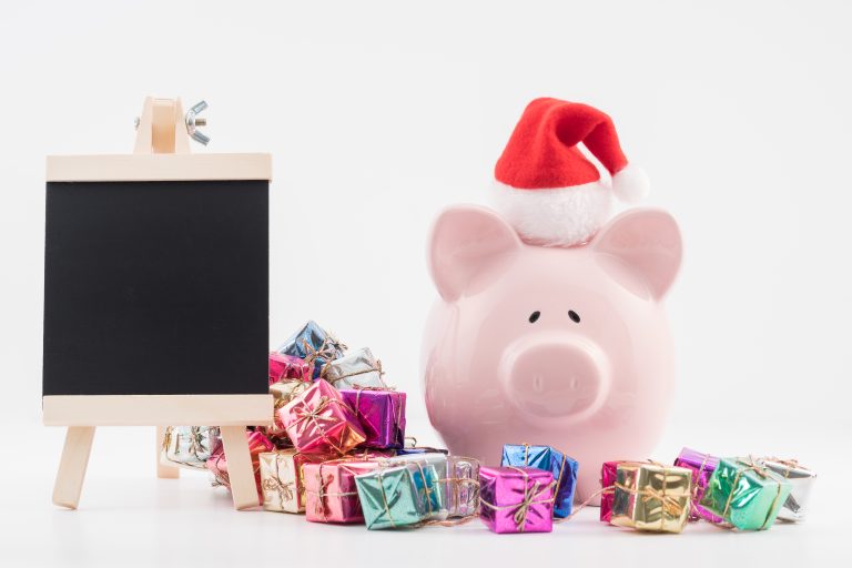 Piggy bank in a Santa Claus hat, chalkboard, and colorful gift boxes