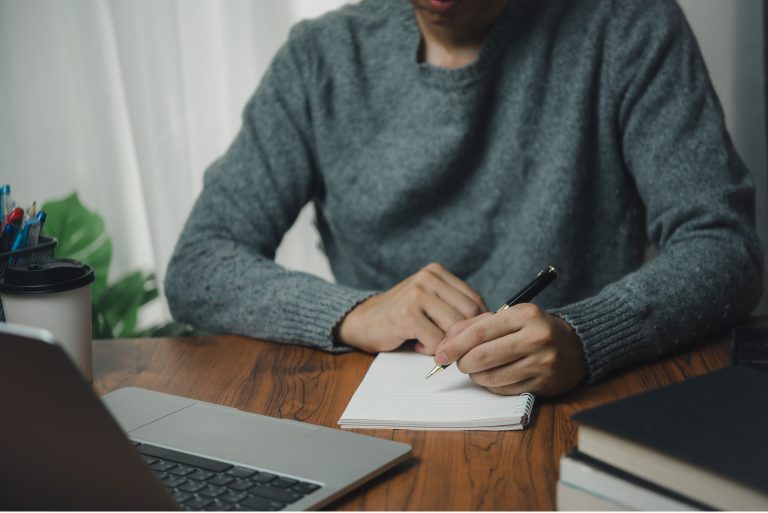 man with learning language during online courses education. e-learning webinar online class by using laptop computer and writing notebook at workplace, development or knowledge improvement concept.